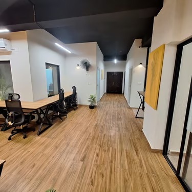 Panda Works workspace hallway with desks and warm wood flooring